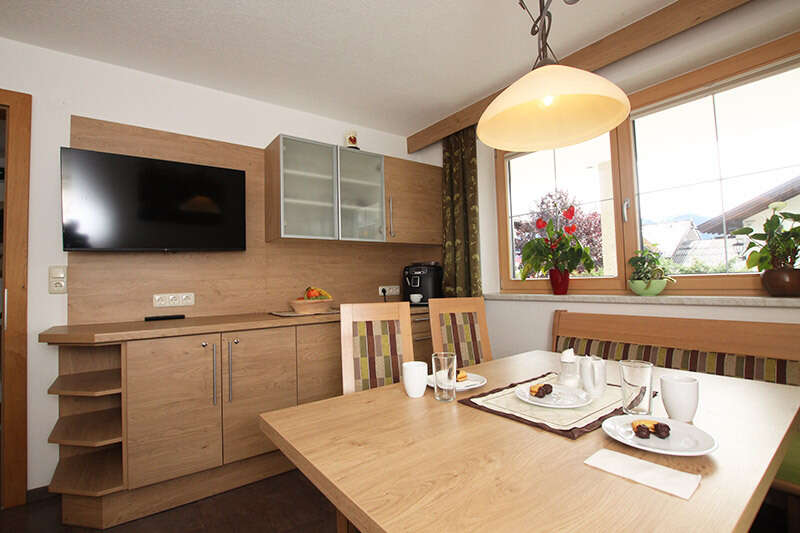 Aufenthaltsraum mit Fernseher im Appartementhaus Alpenhof in Fiss