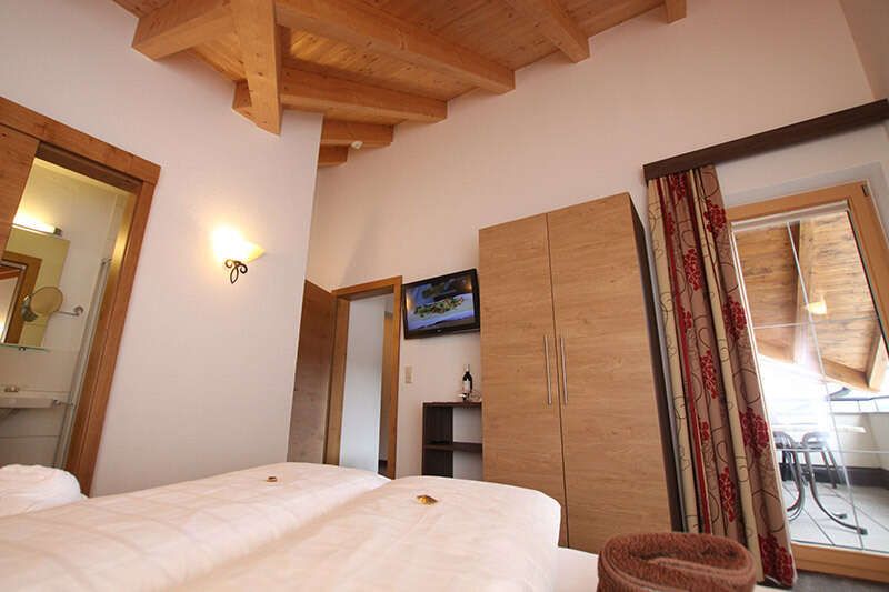 Bedroom with balcony in the Wonne apartment in Tyrol