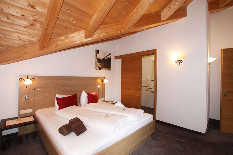 Bedroom with balcony in the Wonne apartment in the Alpenhof Fiss